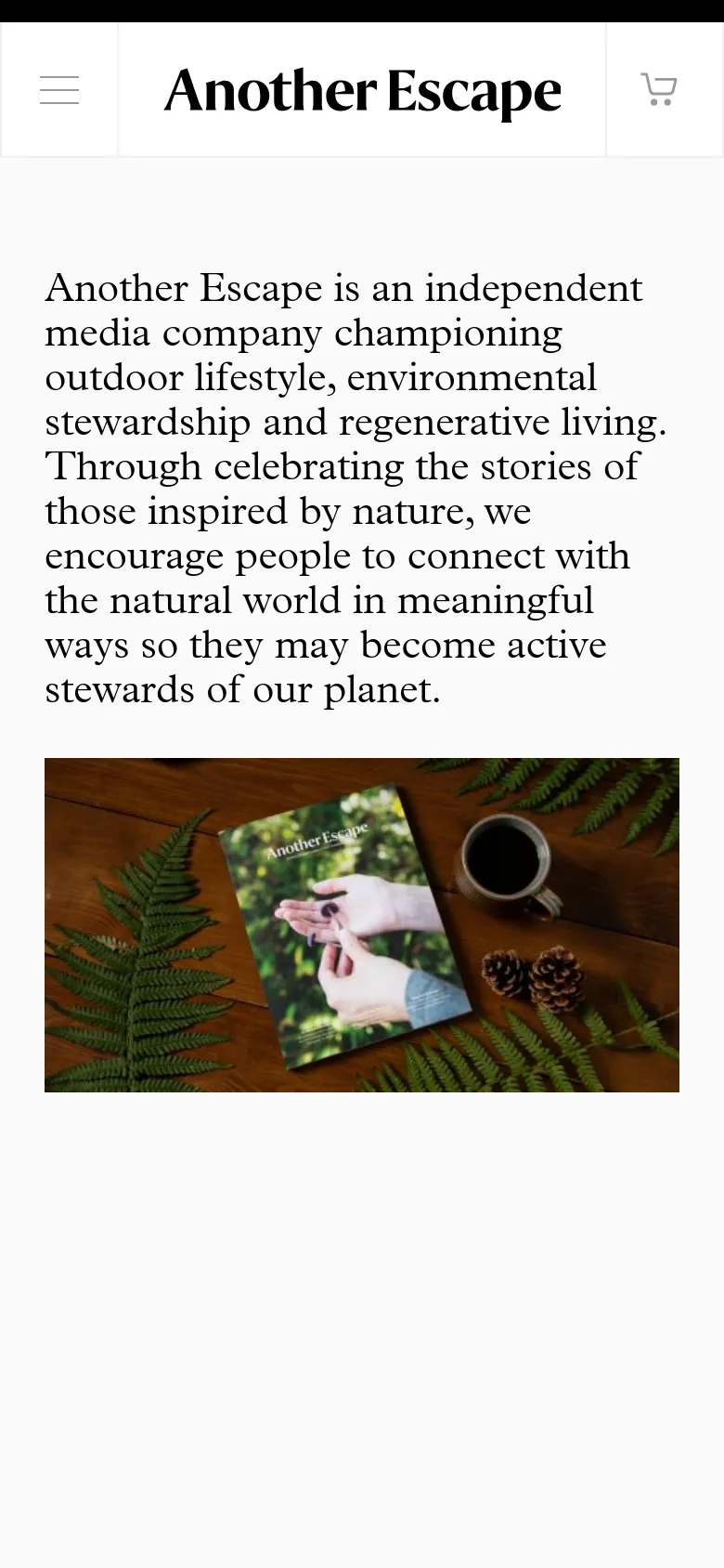 The mobile version presents a simplified single-column layout with the mission statement text stacked vertically. The hero image of the magazine on a wooden surface is centered below the text. Navigation is condensed into a hamburger menu icon on the left and a shopping cart icon on the right of the header.