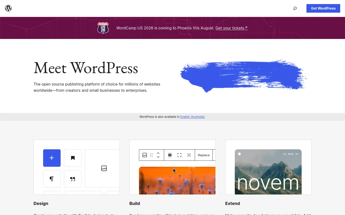 The WordPress homepage features a clean white background with a dark purple announcement banner at the top for WordCamp US 2026. The hero section displays the headline 'Meet WordPress' next to a large blue brushstroke graphic. Below, three feature cards with minimalist icons and illustrations describe 'Design', 'Build', and 'Extend' capabilities.