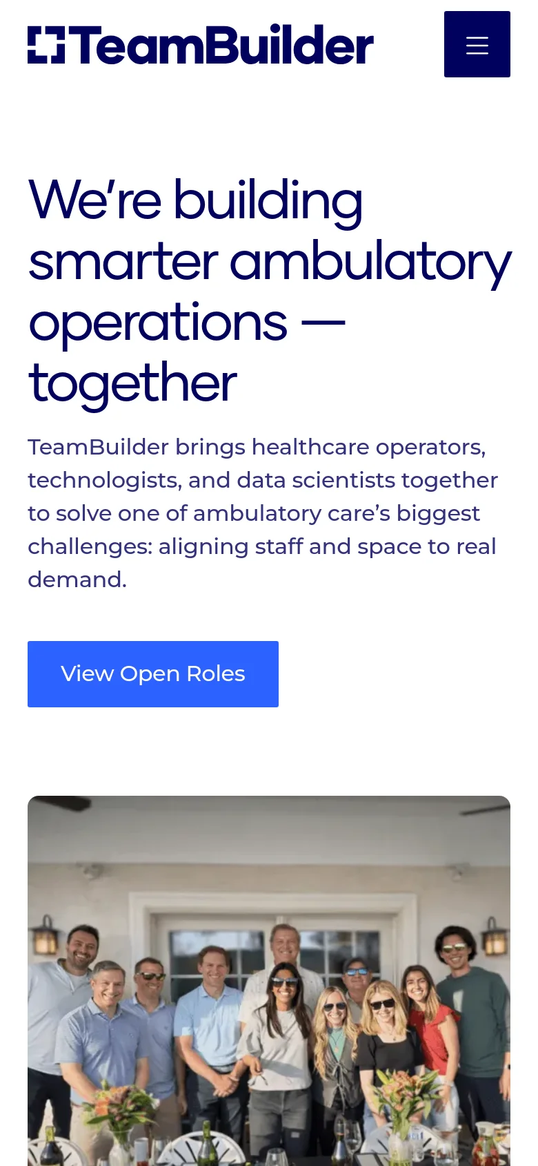 The mobile version uses a single-column layout with the large headline and introductory text stacked vertically above the hero image of the group. The navigation is condensed into a dark blue hamburger menu icon in the top right, and the 'View Open Roles' button spans a significant portion of the screen width.