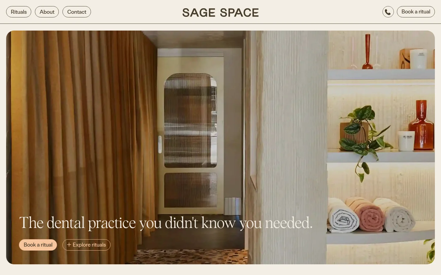 The Sage Space homepage features a minimalist, warm-toned interior design with a large hero image showing a doorway, amber curtains, and shelving with towels and plants. The headline reads 'The dental practice you didn't know you needed' with two primary buttons: 'Book a ritual' and 'Explore rituals'. Navigation links for Rituals, About, and Contact are at the top left, next to the brand name and a phone icon.