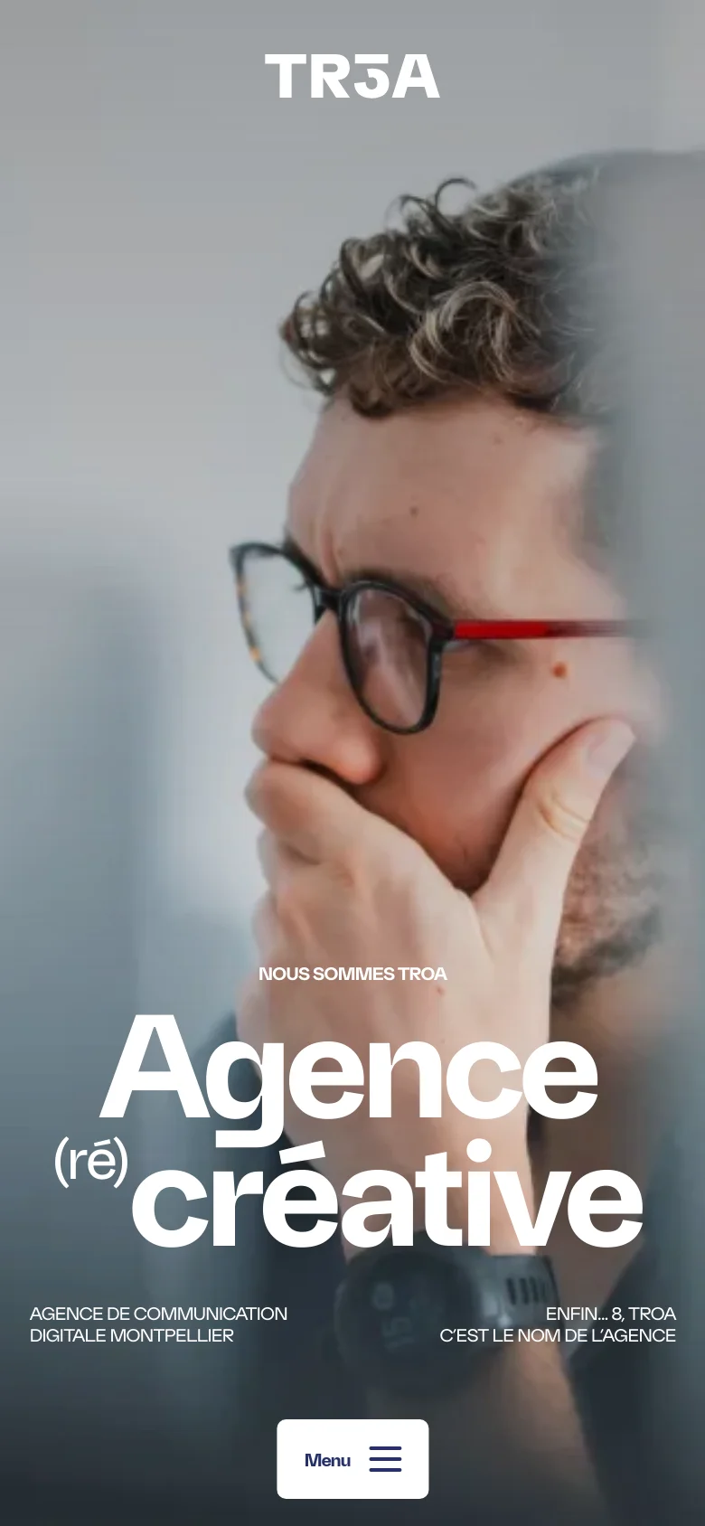 The mobile version presents a vertically oriented hero image of a person in glasses, with the large white headline 'Agence (ré) créative' positioned in the lower half. The top navigation is replaced by a centered 'TR3A' logo, and a prominent white 'Menu' button with a hamburger icon is fixed at the bottom of the screen.