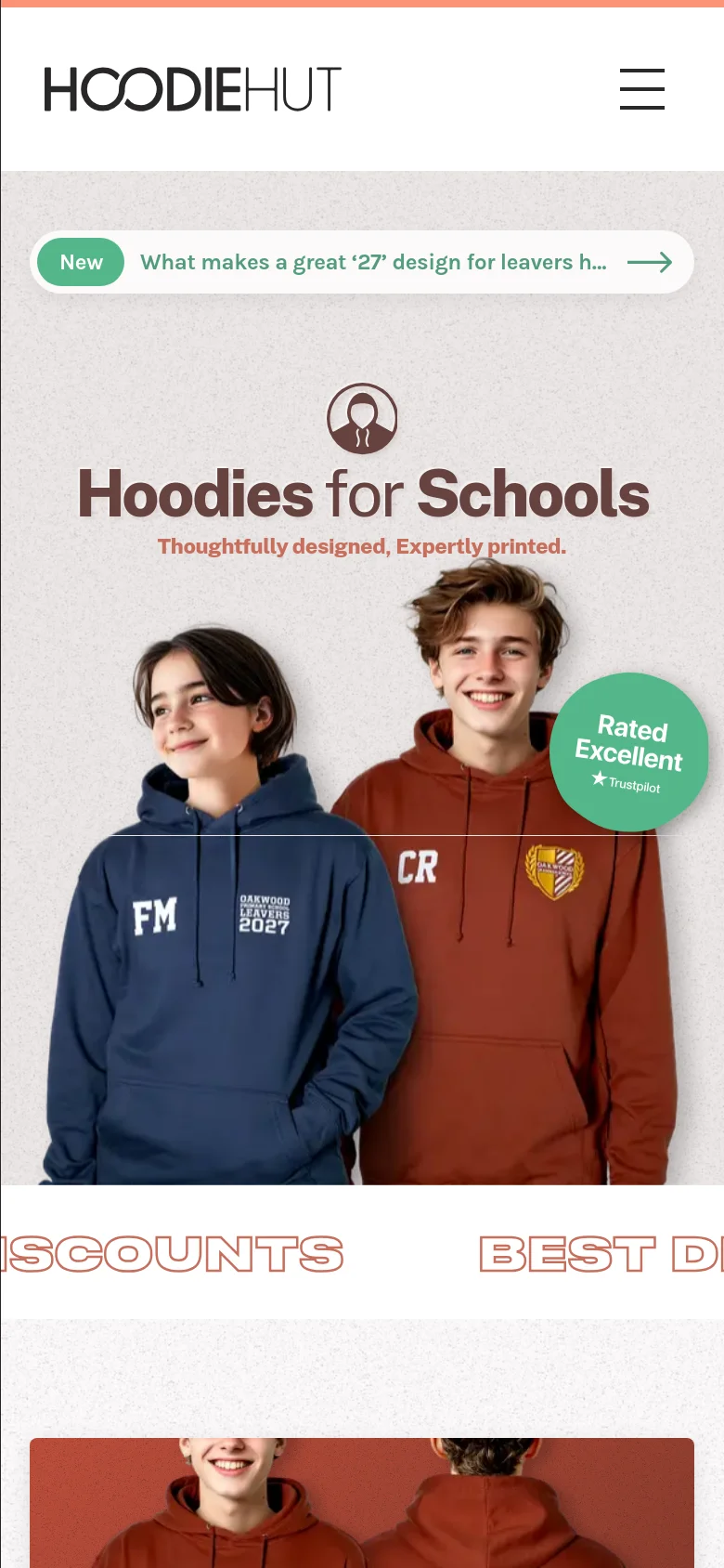 The mobile version presents a simplified layout with a hamburger menu icon for navigation. The hero section remains centered, showing the 'Hoodies for Schools' headline and the two students in personalized hoodies, but the content is scaled vertically to fit the narrower screen.