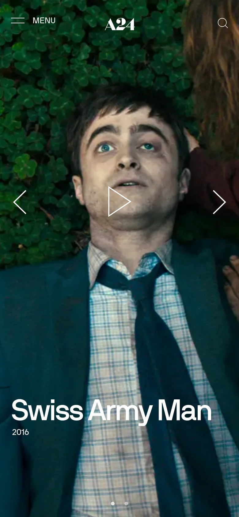 The mobile version displays a vertically oriented, full-screen hero image of the same film scene with the title 'Swiss Army Man' and year '2016' positioned at the bottom. The layout is simplified with a top navigation bar containing a menu icon, the A24 logo, and a search icon, and navigation arrows on the sides of the image.