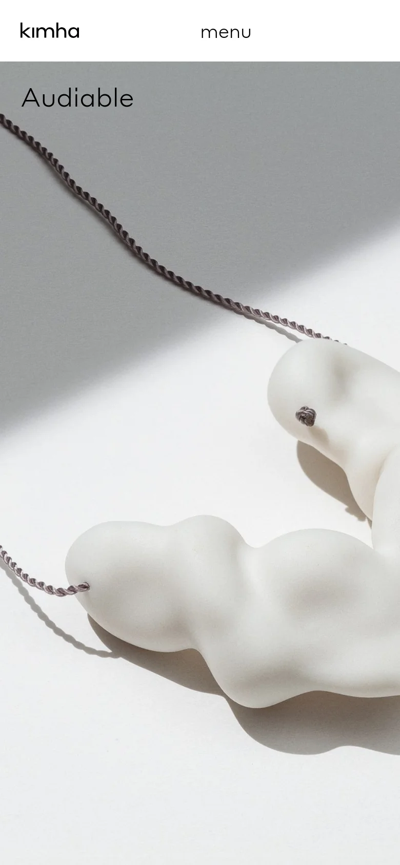 The mobile version displays a simplified layout with a large, zoomed-in version of the sculptural necklace hero image. The navigation is condensed into a 'menu' button next to the 'kimha' logo at the top, and the collection list is not visible in this view.
