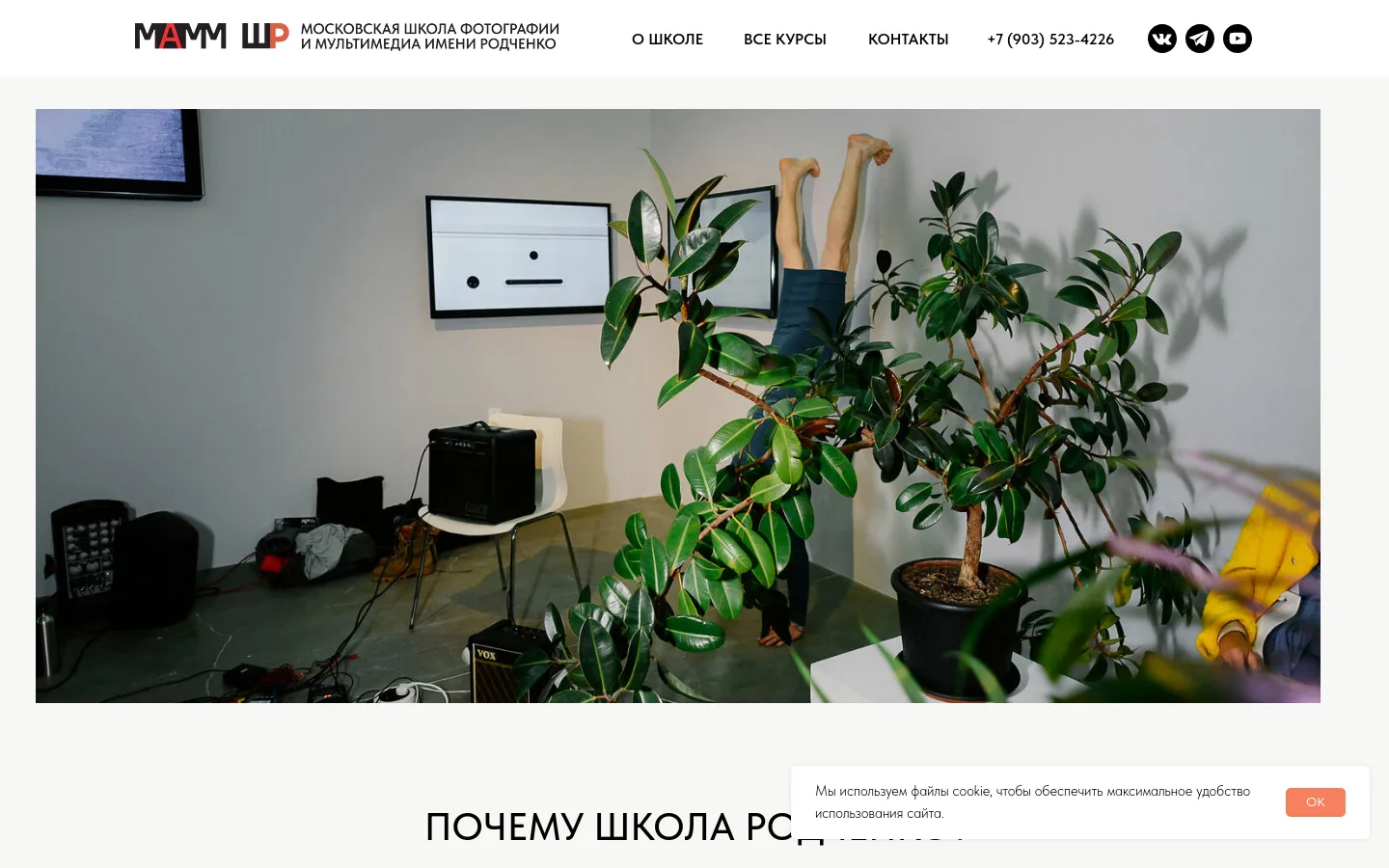 Desktop view of the 'About the School' page featuring a white background and a wide hero image of an art studio with plants and a person performing an acrobatic pose. The navigation bar at the top includes the MAMM and Rodchenko School logos, links for 'About', 'All Courses', and 'Contacts', a phone number, and social media icons. Below the hero image, a large heading reads 'WHY RODCHENKO SCHOOL?' followed by descriptive text in Russian.