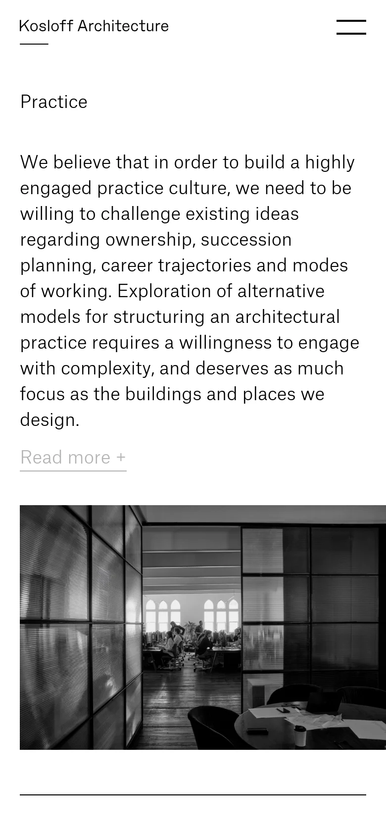 The mobile version uses a single-column vertical layout. The text content is stacked on top, followed by the 'Read more +' link, and then the large black-and-white office interior image is positioned below the text. The header remains consistent with the logo on the left and a two-line menu icon on the right.