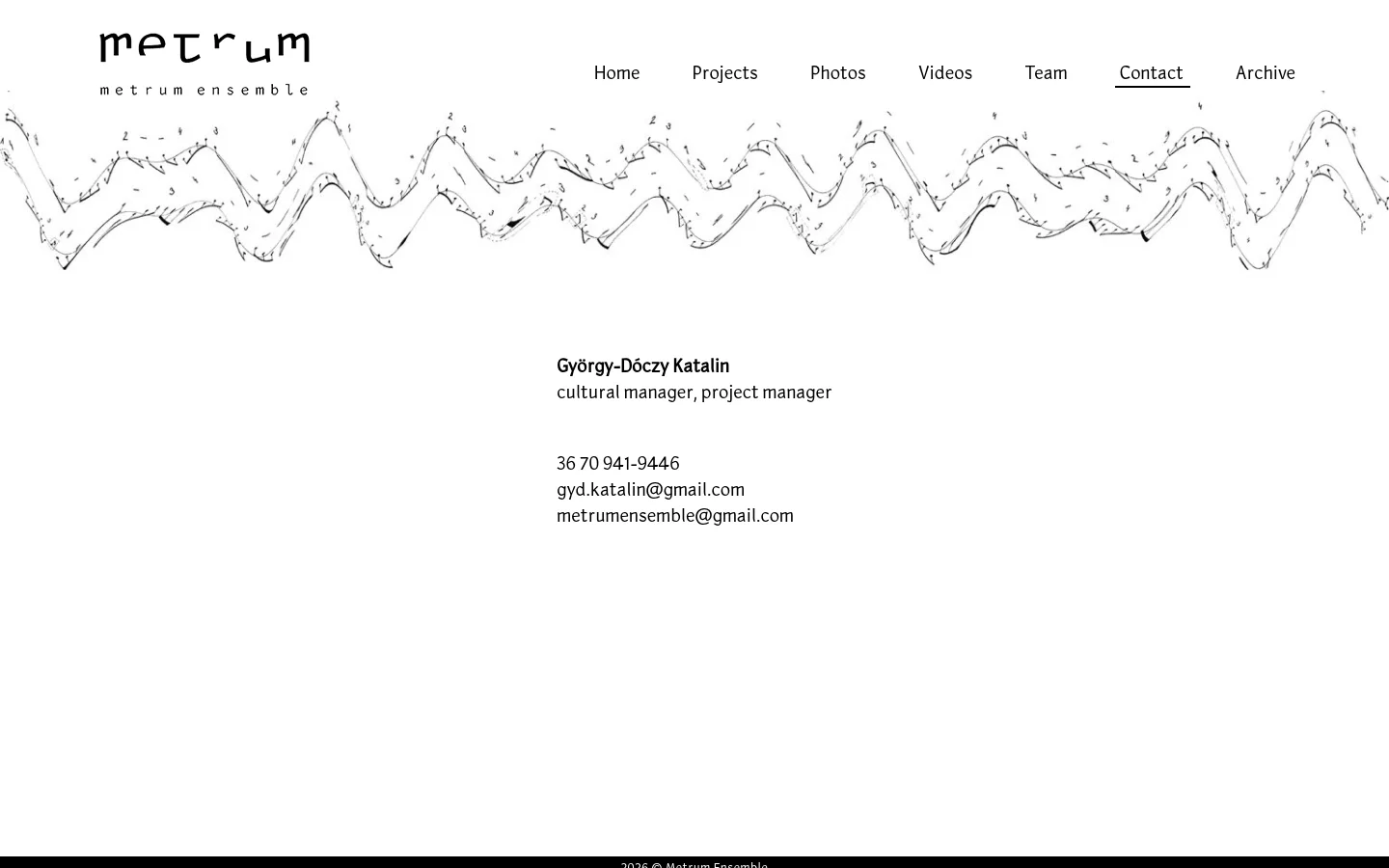 The desktop contact page features a white background with the Metrum Ensemble logo at the top left and a horizontal navigation menu. A stylized, black-and-white wavy line graphic spans the width of the page below the menu. Contact information for György-Dóczy Katalin, including her role, phone number, and two email addresses, is centered in the middle of the page.