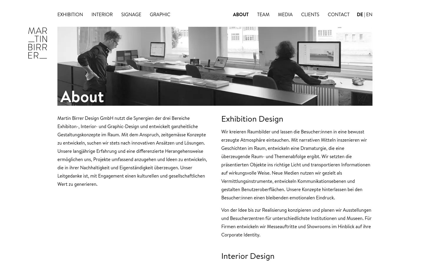 The desktop page features a minimalist white layout with a top navigation menu and a large black and white hero image showing people working in a modern office. Below the hero image, the 'About' text is organized into two columns, with a general introduction on the left and 'Exhibition Design' details on the right.