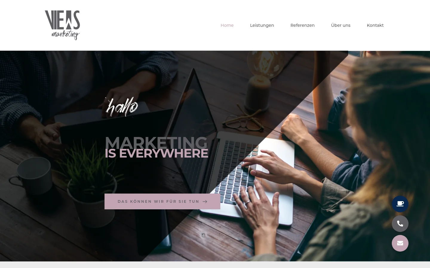 The desktop homepage features a clean white header with the VIEWS Marketing logo on the left and a navigation menu on the right. The hero section uses a large, dark-toned photograph of people working on laptops around a wooden table, overlaid with the bold text 'MARKETING IS EVERYWHERE' and a pink call-to-action button that reads 'DAS KÖNNEN WIR FÜR SIE TUN'. Floating circular icons for coffee, phone, and email are positioned in the bottom right corner.