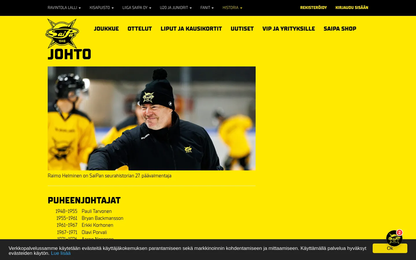 The desktop page features a bright yellow background with a black header and footer. A large hero image shows Raimo Helminen, a smiling man in a black beanie and jacket, with a list of chairpersons, CEOs, and head coaches organized in columns below.