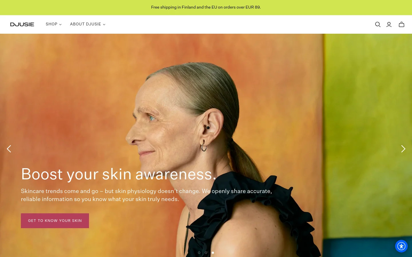 The desktop homepage features a minimalist white header with the Djusie logo, navigation links, and icons for search, account, and cart. A large hero image shows a profile view of a woman against a warm orange and green background, overlaid with the headline 'Boost your skin awareness' and a pink 'GET TO KNOW YOUR SKIN' button. A lime green announcement bar at the top reads 'Free shipping in Finland and the EU on orders over EUR 89'.