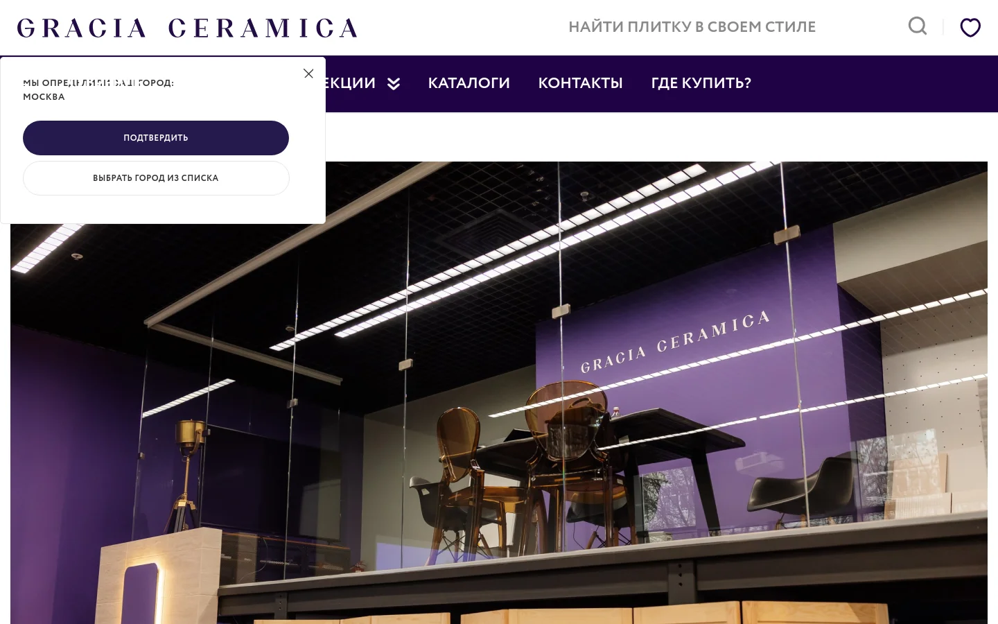 The desktop page for Gracia Ceramica features a large hero image of a modern interior viewed through a glass partition. A dark purple navigation bar at the top contains links for collections, catalogs, contacts, and a 'where to buy' section, alongside a city selection pop-up. The brand logo is prominently displayed in a serif font against a white header.
