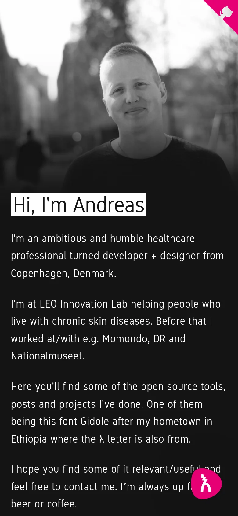 Mobile version of the homepage with a vertically oriented layout. The black-and-white portrait of Andreas fills the top half of the screen, with the 'Hi, I'm Andreas' heading and biography text stacked below it on a dark background. A bright pink circular icon is visible in the bottom right corner.