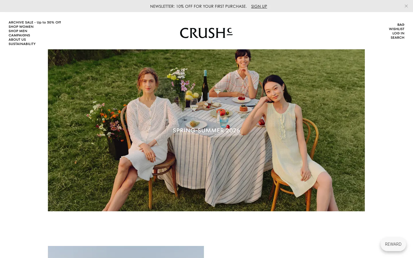 The desktop homepage for CRUSH Collection features a minimalist design with a large hero image of three women sitting at an outdoor dining table in a grassy field. A navigation menu is positioned on the left, while the brand logo is centered at the top, and links for Bag, Wishlist, Log In, and Search are on the right. The color palette is natural and airy, dominated by greens, whites, and soft tones.