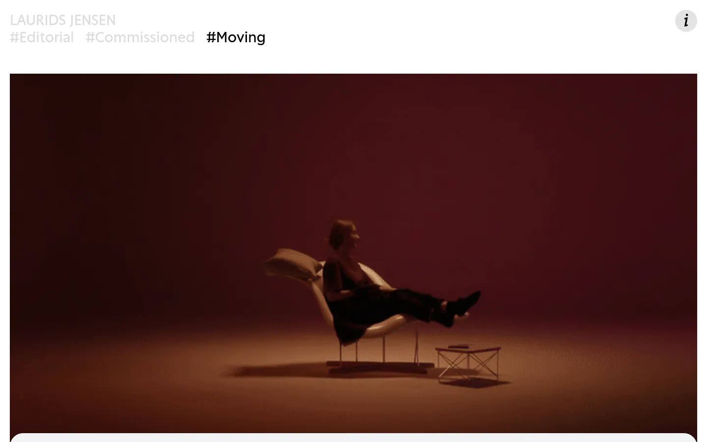 The desktop page features a minimalist white header with the name 'LAURIDS JENSEN' and navigation links for Editorial, Commissioned, and Moving. Below the header, a large video player displays a cinematic shot of a person sitting in a chair against a deep reddish-brown background. The layout is clean with significant whitespace and dark, moody visual content.