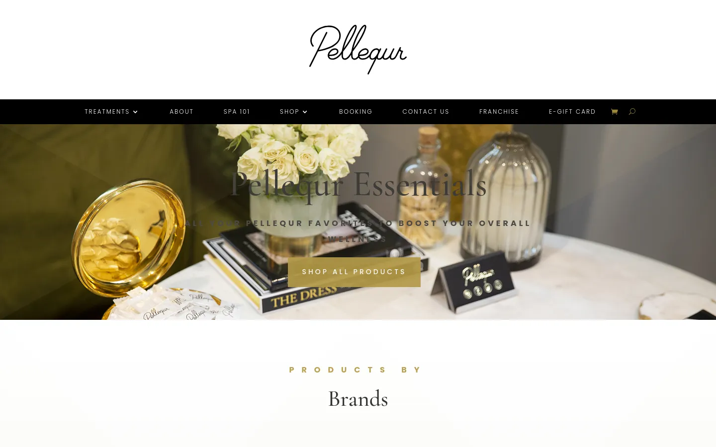 The desktop shop page features a large hero image of luxury wellness products, white roses, and gold accents with the headline 'Pellequr Essentials' and a gold 'Shop All Products' button. A black navigation bar sits above the hero image, and below it, the page transitions into a clean white layout with gold text headings for 'Products by Brands'.