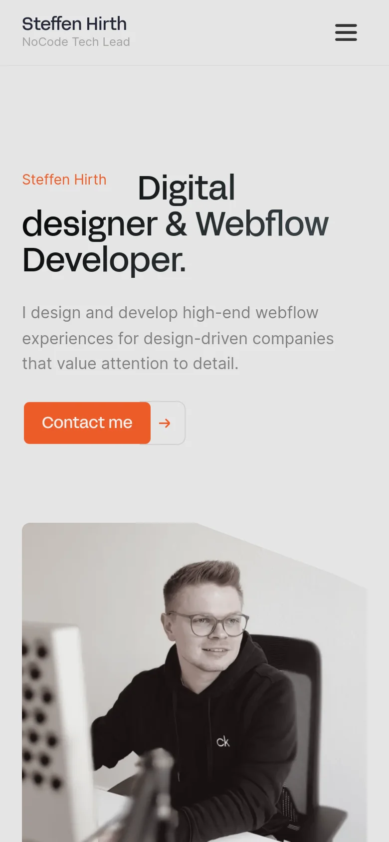 Mobile version of the homepage featuring a stacked layout. The navigation is condensed into a hamburger menu icon at the top right, while the hero section displays the headline and 'Contact me' button above a large portrait of Steffen Hirth. The color palette remains a minimalist light gray with high-contrast black text and an orange primary button.