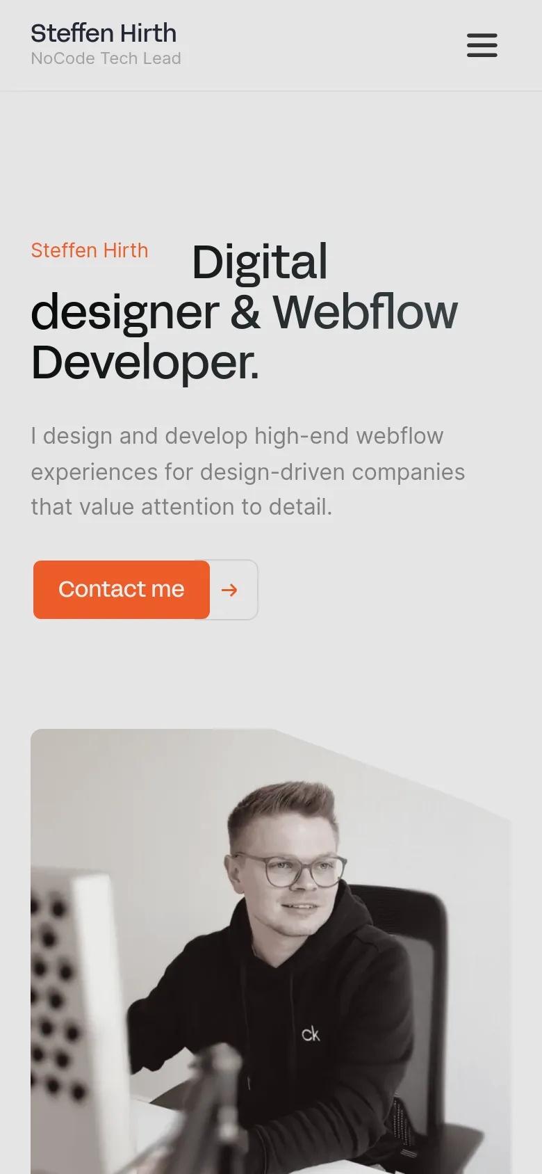 Mobile version of the homepage featuring a stacked layout. The navigation is condensed into a hamburger menu icon at the top right, while the hero section displays the headline and 'Contact me' button above a large portrait of Steffen Hirth. The color palette remains a minimalist light gray with high-contrast black text and an orange primary button.