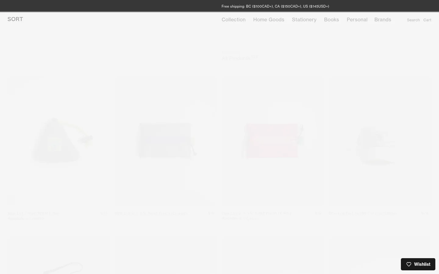 The desktop view shows a minimalist e-commerce product grid on a light gray background with a top navigation bar containing links for Collection, Home Goods, Stationery, Books, Personal, Brands, Search, and Cart. The main content area displays a heading 'Viewing: All Products' followed by a grid of product images, including items like the Blue Lug Onigiri Sheet, each with its title, color options, and price listed below. A 'Wishlist' button with a heart icon is positioned in the bottom right corner.