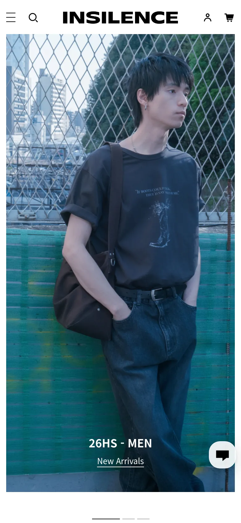 The mobile version displays a simplified header with a hamburger menu, search icon, brand logo, user profile, and shopping cart. The hero image is vertically oriented, showing a young man in a dark t-shirt and jeans leaning against a chain-link fence. The '26HS - MEN' headline and 'New Arrivals' link are positioned at the bottom of the screen over a chat icon.