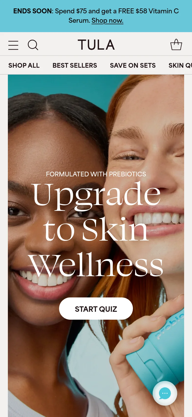 The mobile version displays a vertically oriented hero image of the same two women, with the headline 'Upgrade to Skin Wellness' stacked centrally. The 'START QUIZ' button is prominent in the middle of the screen. The layout is condensed, featuring a hamburger menu, search icon, and a shopping bag icon in the header, with a floating chat bubble at the bottom right.