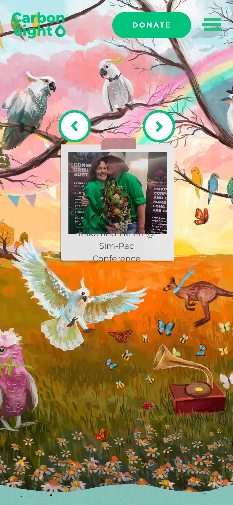 The mobile version presents a vertically stacked layout with the colorful illustrated background. The central image card is scaled down to fit the screen width, showing Mike and Helen at the Sim-Pac Conference. The header is simplified, featuring the Carbon8 logo, a large green 'Donate' button, and a hamburger menu icon.