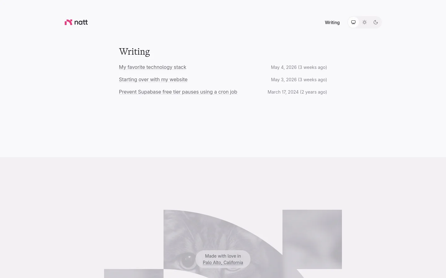 A minimalist writing page with a white background and dark text. The layout features a clean header with the 'natt' logo, a 'Writing' link, and theme toggle icons, followed by a list of article titles with their publication dates. The footer contains a stylized grayscale image of a cat and a small text box stating 'Made with love in Palo Alto, California'.