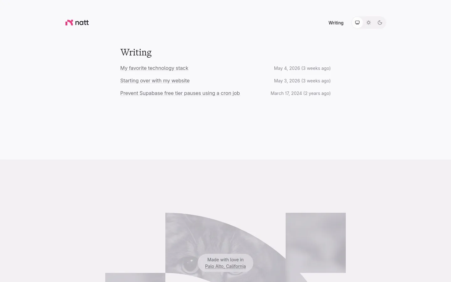 A minimalist writing page with a white background and dark text. The layout features a clean header with the 'natt' logo, a 'Writing' link, and theme toggle icons, followed by a list of article titles with their publication dates. The footer contains a stylized grayscale image of a cat and a small text box stating 'Made with love in Palo Alto, California'.