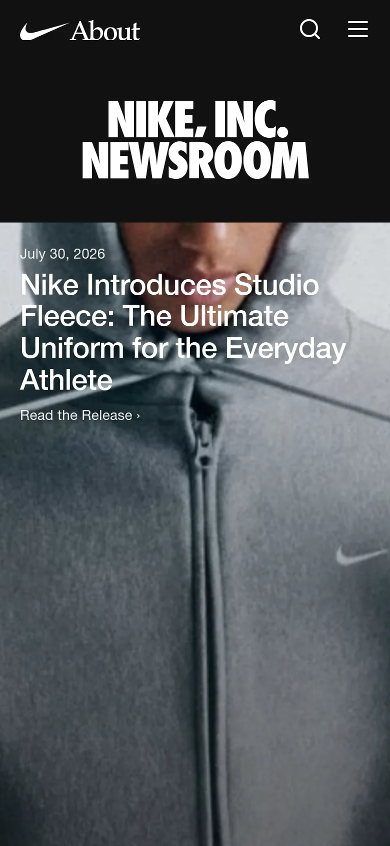 The mobile version features a condensed header with the Nike About logo, a search icon, and a hamburger menu icon. The 'NIKE, INC. NEWSROOM' title is prominently centered in white text on a black background, followed by a full-width hero image of a person in a grey hoodie with the headline 'Nike Introduces Studio Fleece: The Ultimate Uniform for the Everyday Athlete' overlaid on the image.