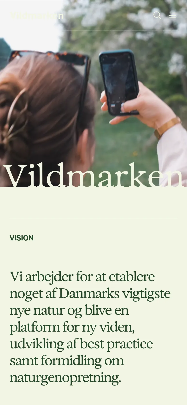 The mobile version presents a vertically stacked layout optimized for small screens, starting with the large nature hero image and the 'Vildmarken' title. The 'Vision' section follows with large, readable serif text on a light beige background. Navigation is condensed into a hamburger menu icon at the top right, replacing the horizontal desktop menu.