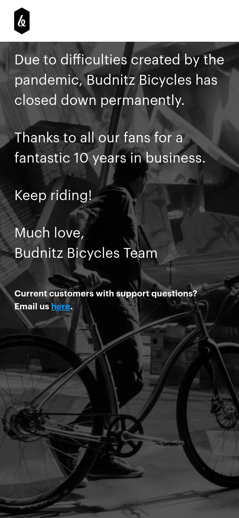 The mobile version presents a vertically oriented black and white image of a person with a bicycle. The text announcement regarding the permanent closure is centered and occupies the upper half of the screen, with the support email link positioned near the bottom.