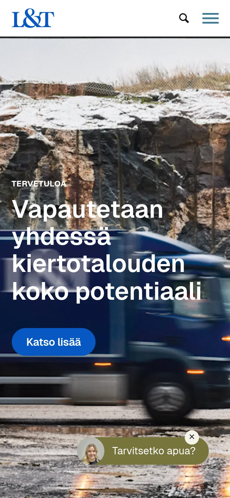 The mobile version displays a simplified header with the L&T logo, a search icon, and a hamburger menu icon. The hero section features the same headline and blue call-to-action button over a background image of a vehicle and rocky landscape, with a floating chat widget at the bottom.