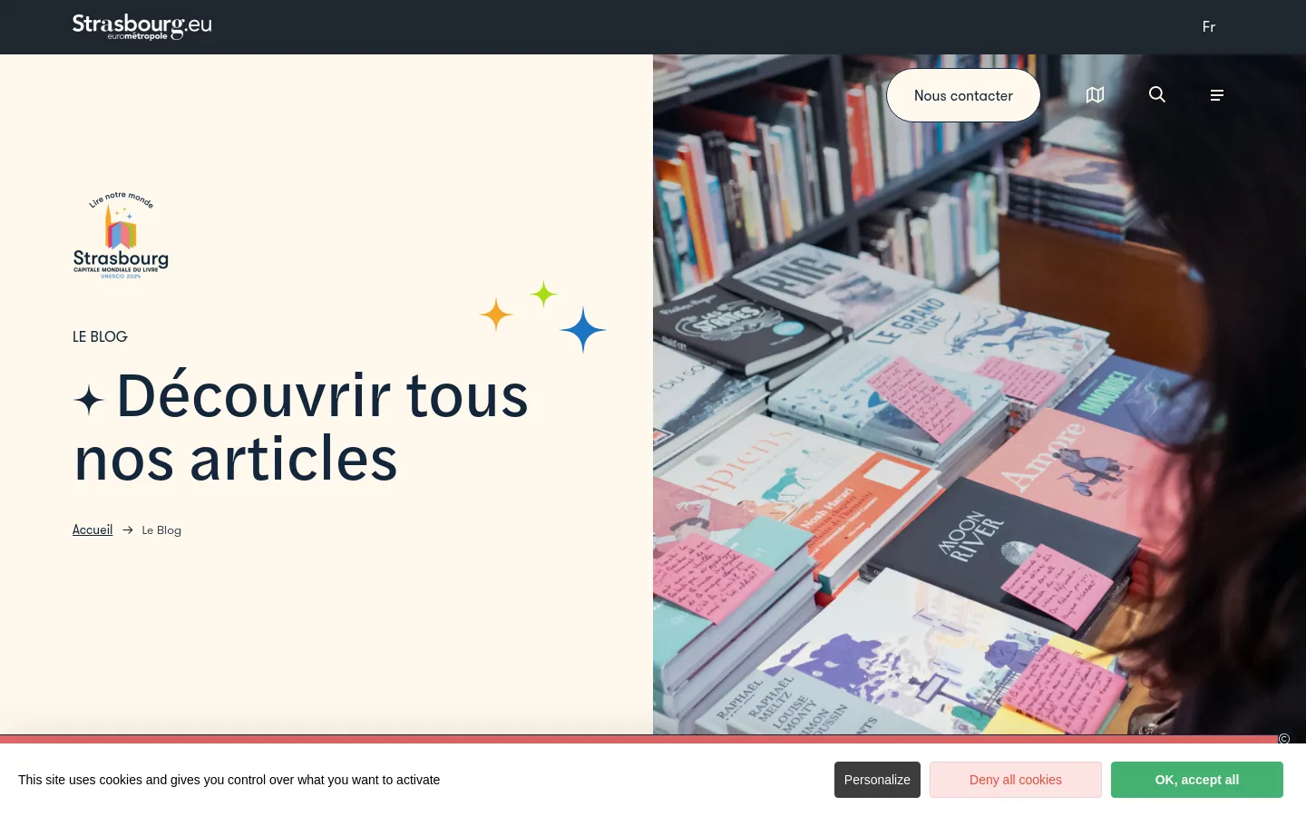 The desktop blog landing page features a split-screen layout with a cream-colored left side containing the logo, 'LE BLOG' heading, and a large title 'Découvrir tous nos articles'. The right side shows a high-quality photograph of a person looking at books on a shelf. A dark navigation bar at the top includes the Strasbourg logo, a 'Nous contacter' button, and search and menu icons.