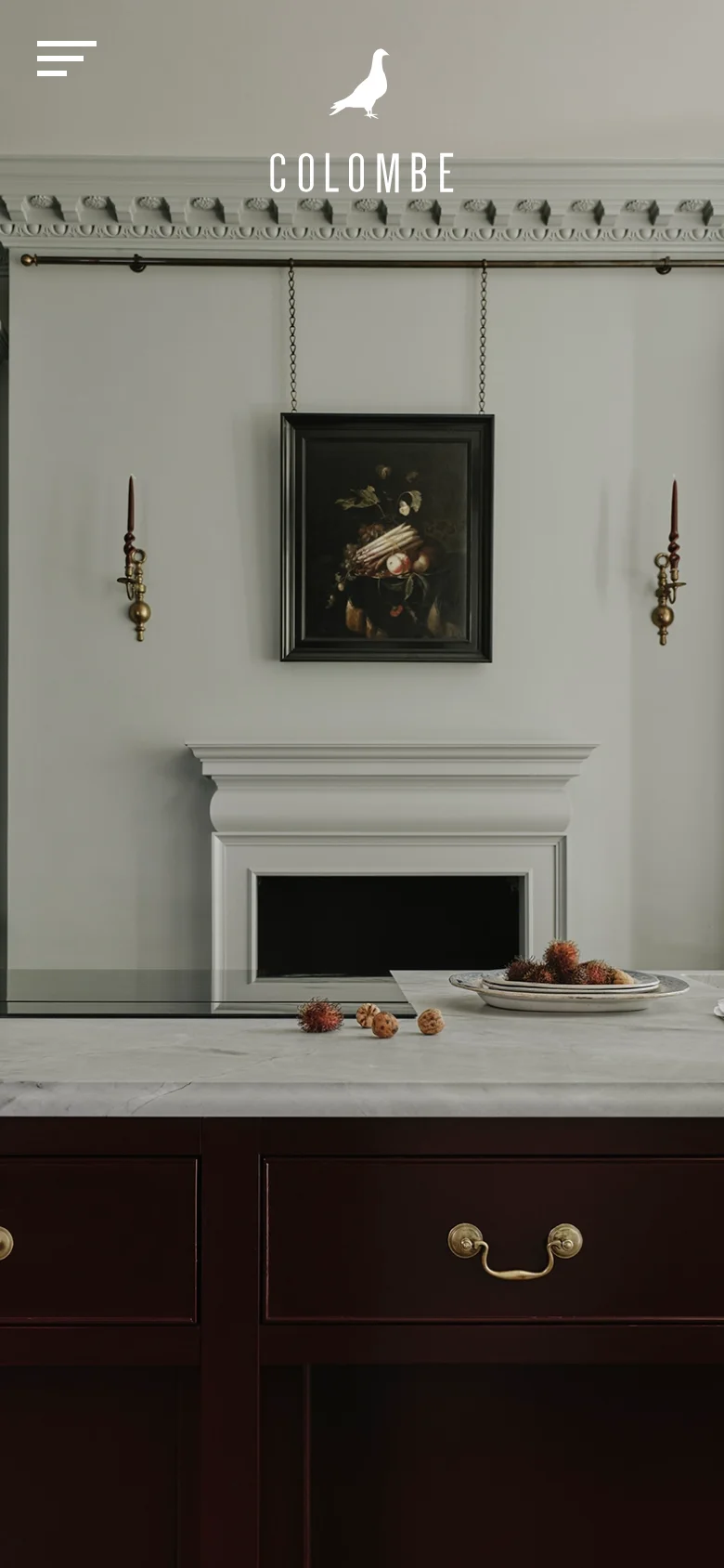 The mobile version displays the same elegant kitchen hero image but uses a simplified layout. The top navigation is replaced by a white hamburger menu icon on the left, with the bird logo and 'COLOMBE' text centered prominently above the image.