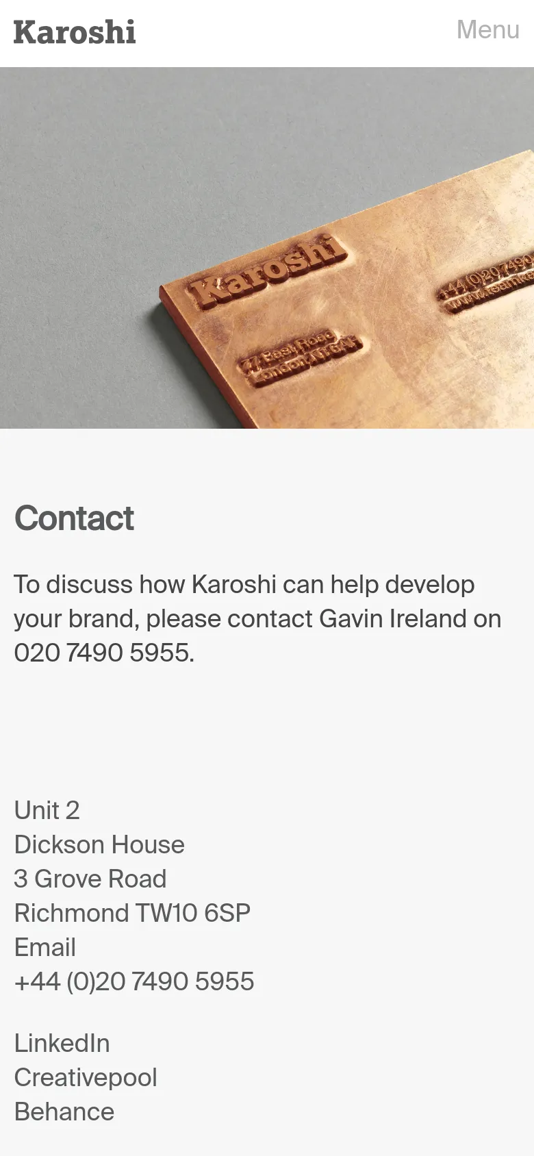 The mobile version simplifies the layout, replacing the top navigation with a 'Menu' label. The hero image remains prominent, while the contact information and address are stacked vertically below the image for easier scrolling on a smaller screen.