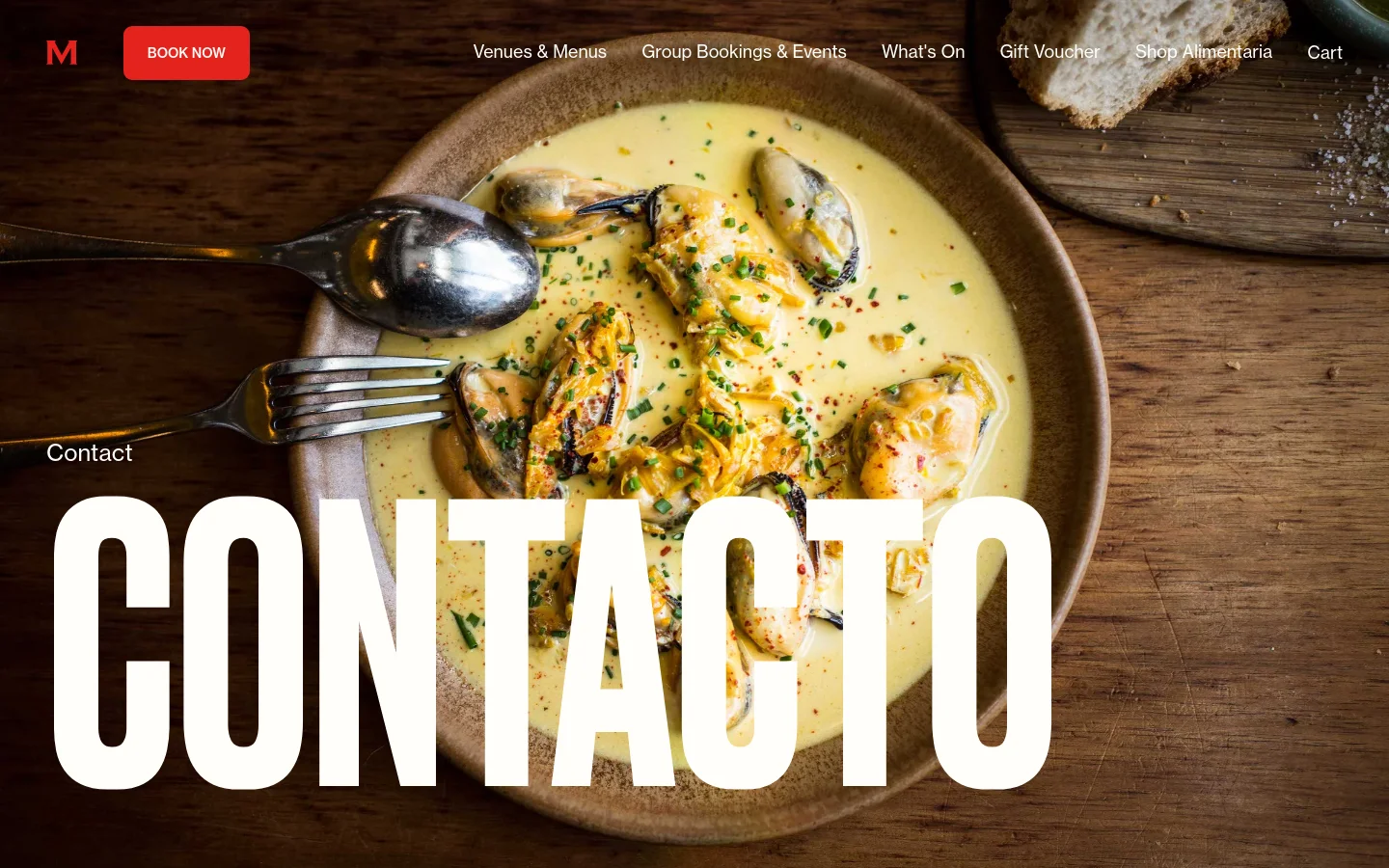 The desktop contact page features a large hero image of mussels in a creamy yellow sauce, overlaid with the large white heading 'CONTACTO'. A navigation bar at the top includes the MoVida logo, a red 'BOOK NOW' button, and links for Venues, Group Bookings, What's On, Gift Vouchers, Shop Alimentaria, and Cart.