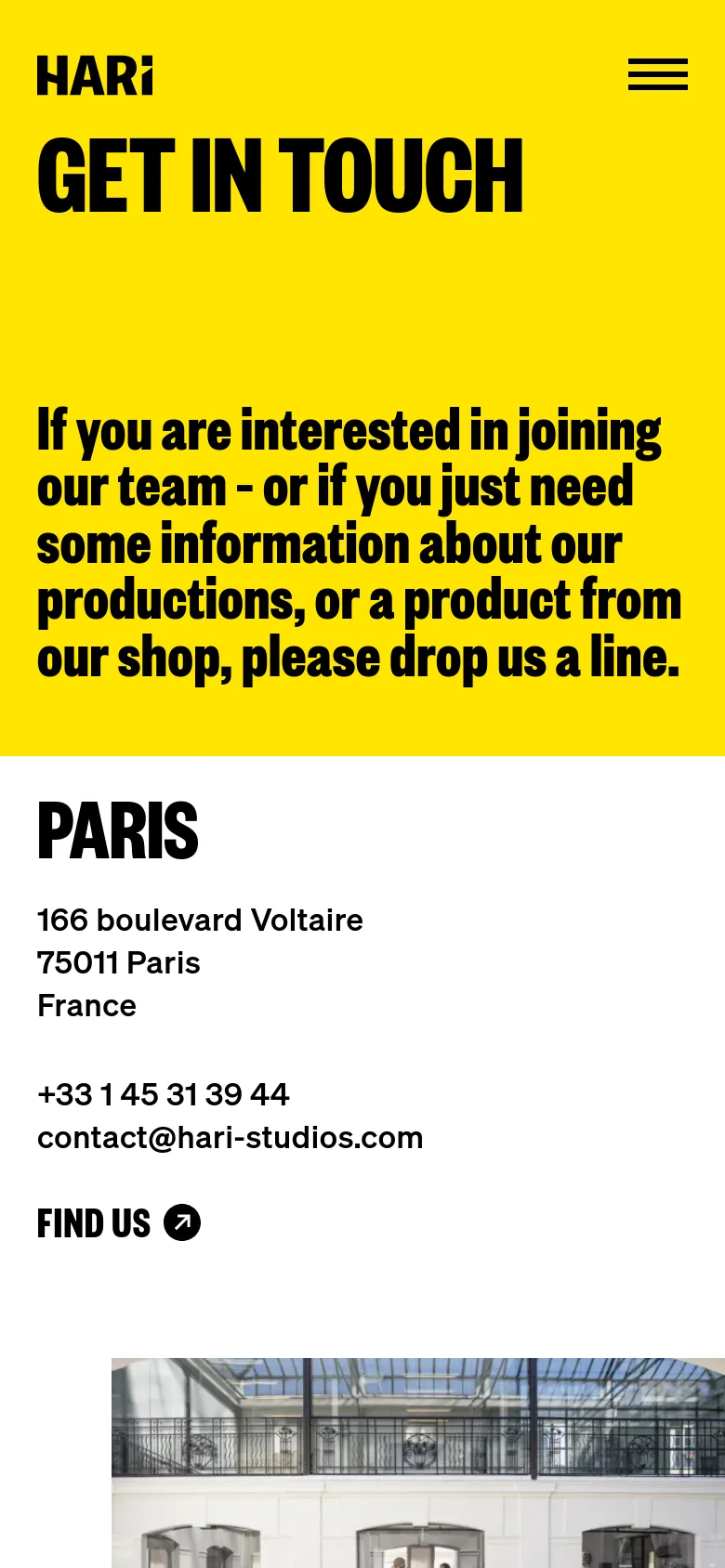 The mobile version maintains the vibrant yellow hero section with large black text, but the layout is vertically stacked for a single-column view. The navigation is condensed into a hamburger menu icon at the top right. Contact information for Paris is displayed clearly below the hero section, followed by an architectural image.