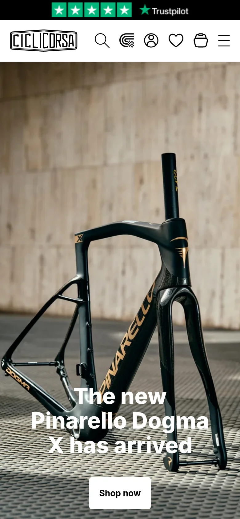 The mobile version displays a vertically oriented hero image of the Pinarello Dogma X bike frame. The headline and 'Shop now' button are centered over the image, and the navigation is condensed into a hamburger menu icon next to search, account, and cart icons at the top.