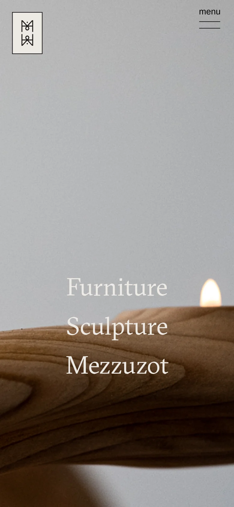 The mobile version presents a vertically oriented hero image of the wooden candle vessel, with the text links 'Furniture', 'Sculpture', and 'Mezzuzot' stacked vertically in the center. The header is simplified, featuring only the brand logo on the left and a 'menu' hamburger icon on the right.
