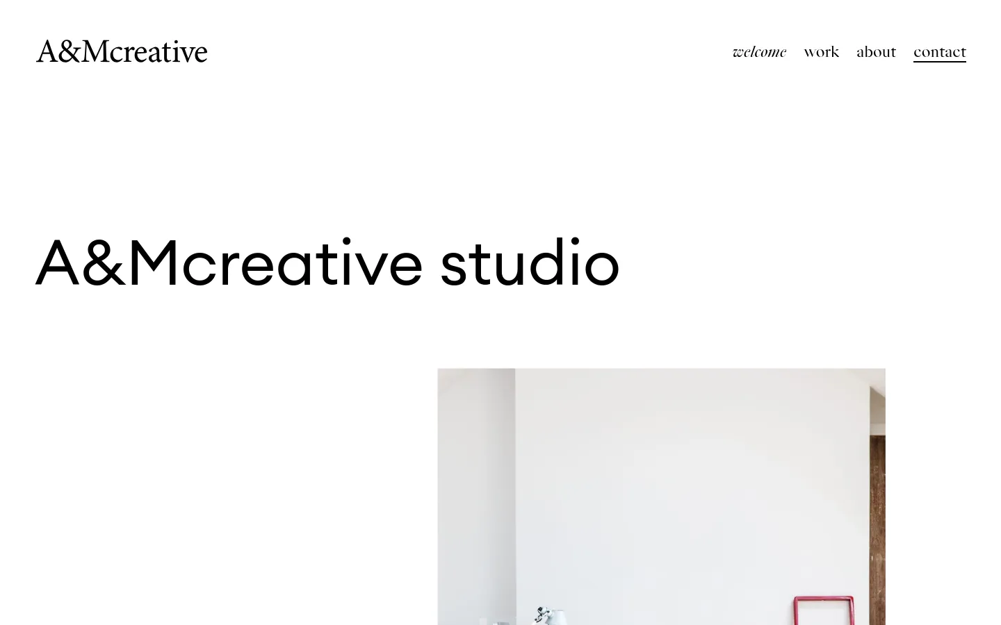 The desktop contact page features a minimalist white layout with the A&Mcreative logo at the top left and navigation links at the top right. A large headline reads 'A&Mcreative studio' above a bright, high-key photograph of a modern, white-walled studio interior with a desk and a red ladder. The design uses ample white space and black serif typography.