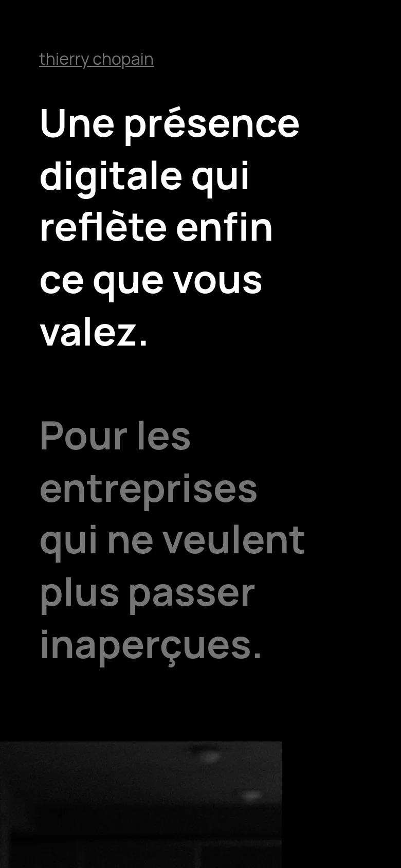 The mobile version presents a vertically stacked, single-column layout optimized for small screens. The large white headline and subheadline dominate the top of the black interface, followed by a simplified navigation and a condensed 'About' section. The design maintains the high-contrast, premium aesthetic of the desktop version but removes side-aligned decorative text.