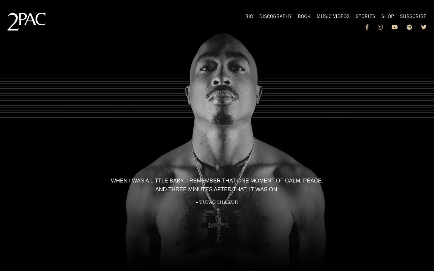 The official 2Pac website features a large, black and white hero image of Tupac Shakur centered against a black background with thin horizontal lines. A quote by Tupac is overlaid on his chest, and the top navigation includes the 2Pac logo, links like Bio and Discography, and social media icons.