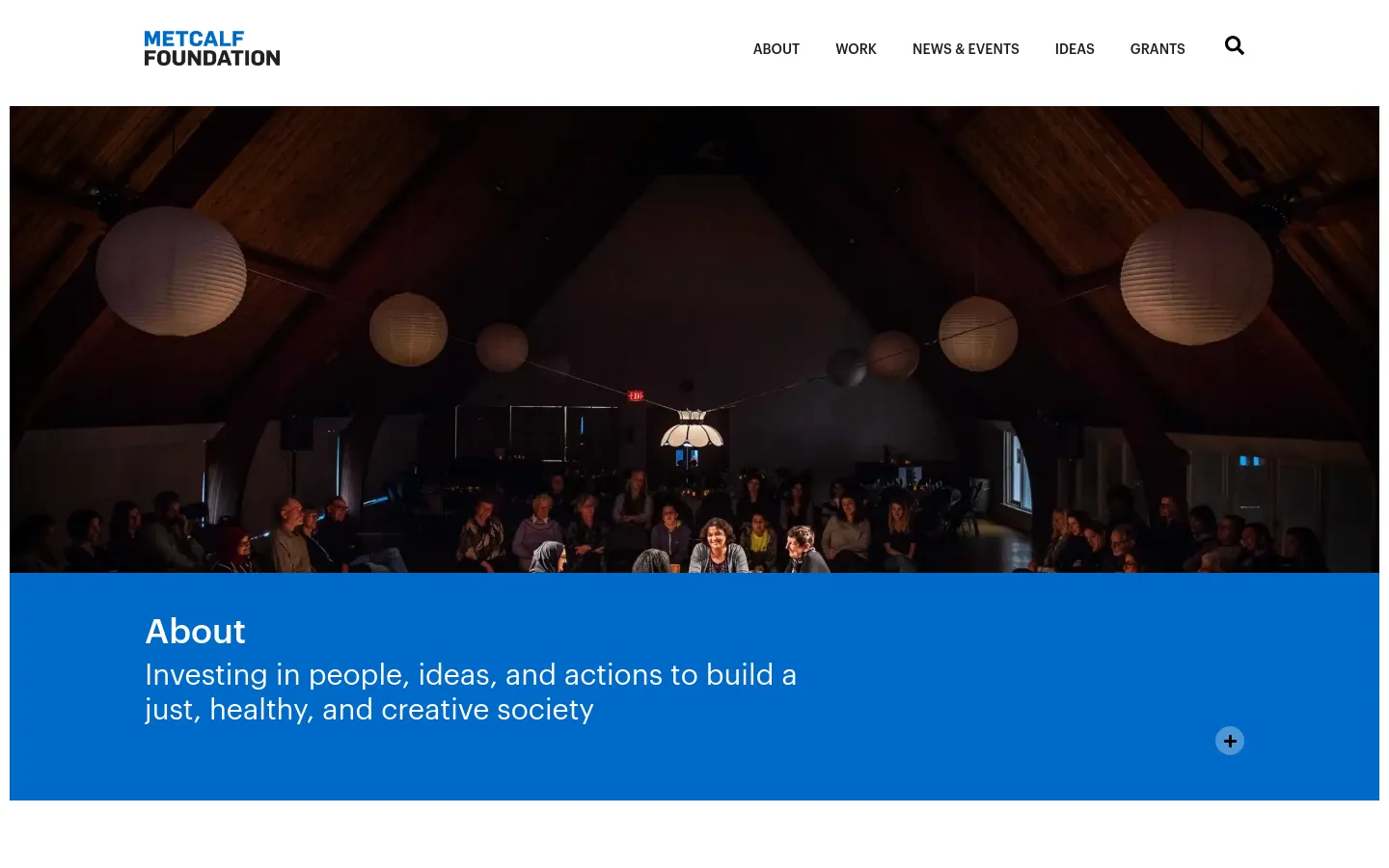 The desktop About page features a large hero image of an audience in a dimly lit theater with hanging paper lanterns. Below the image, a bright blue banner contains the heading 'About' and the foundation's mission statement, with a navigation menu at the top including links for About, Work, News & Events, Ideas, and Grants.