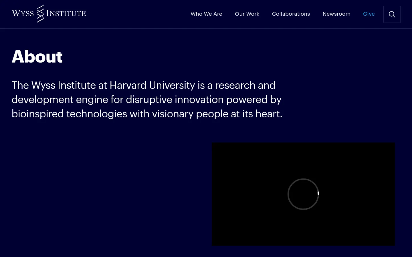 The desktop About page features a dark navy blue background with white text. A large 'About' headline is followed by a mission statement, positioned to the left of a large black rectangular video placeholder. The top navigation bar includes the Wyss Institute logo, links for 'Who We Are', 'Our Work', 'Collaborations', 'Newsroom', and 'Give', alongside a search icon.