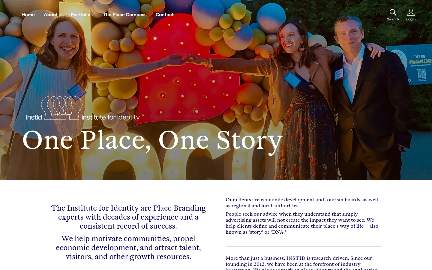 The homepage features a large hero image of four smiling people celebrating with colorful balloons and a large red number against a dark background. A white headline reads 'One Place, One Story' over the image, with a navigation menu at the top and the 'instid institute for identity' logo. Below the hero section, a white area contains dark blue text describing the company's expertise in place branding.