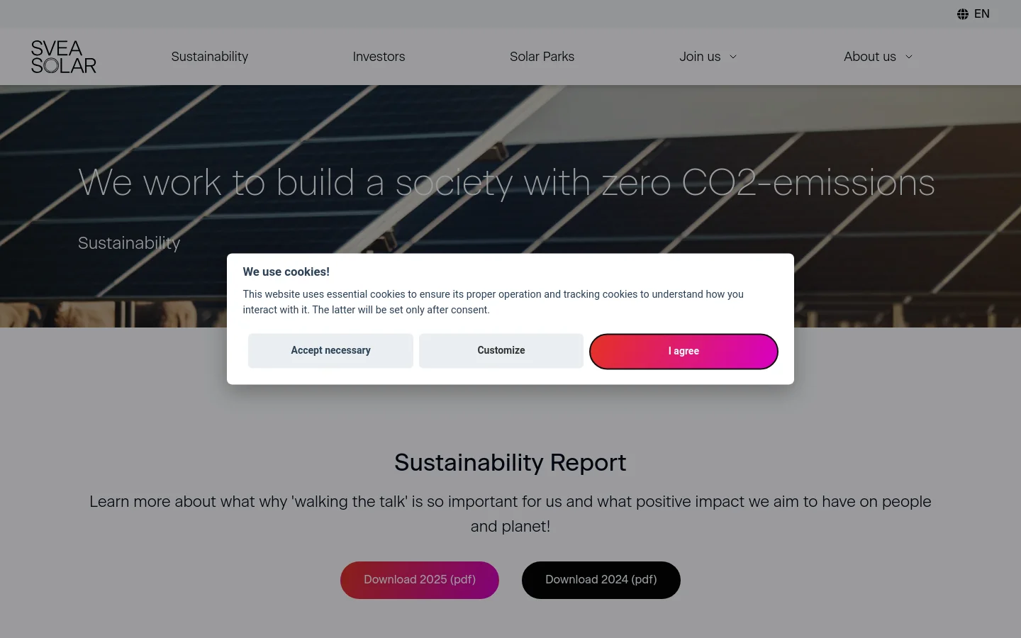 The desktop page features a large hero image of solar panels under a sunset sky with the headline 'We work to build a society with zero CO2-emissions'. Below, a light gray section contains the 'Sustainability Report' heading and two prominent call-to-action buttons to download PDF reports for 2025 and 2024. A cookie consent modal is overlaid in the center of the screen.