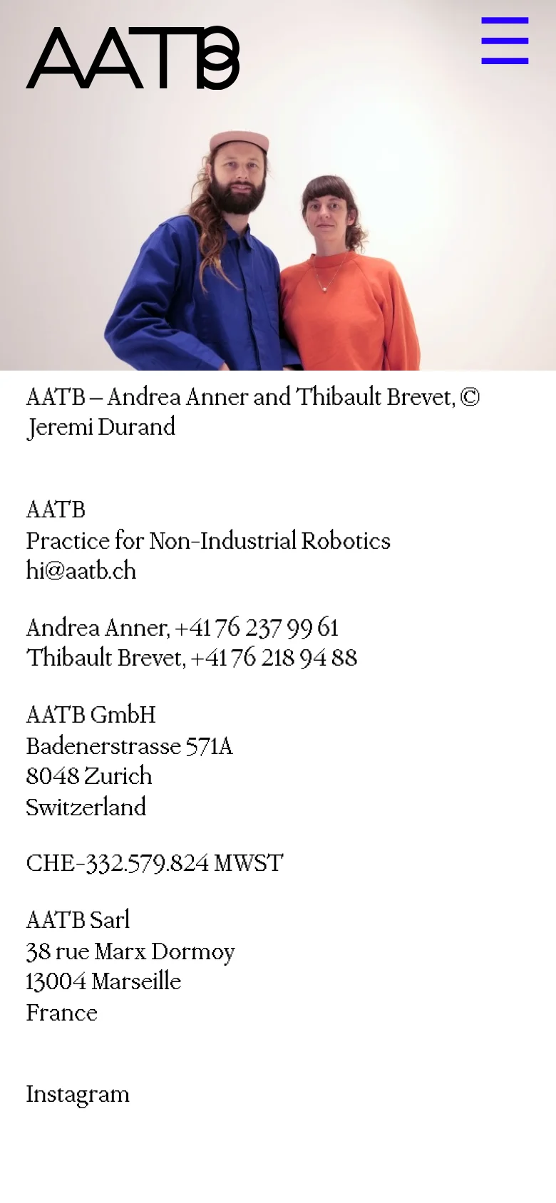 The mobile version displays the same hero image of the two individuals at the top, but the layout is vertically stacked. A large 'AATB' logo and a blue hamburger menu icon appear above the image. The contact information and studio addresses follow below in a single-column text format.
