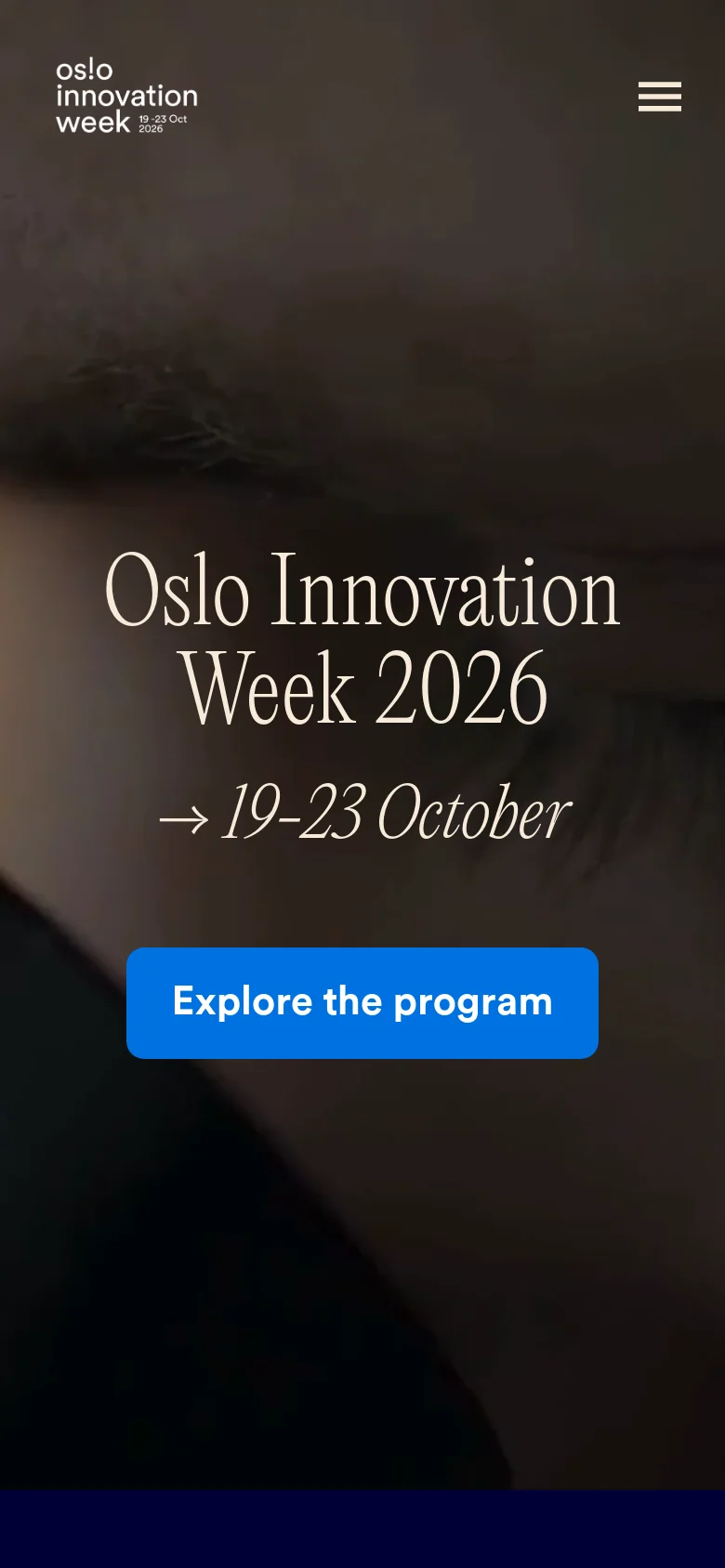 The mobile version presents a vertically oriented layout with the hero image and text centered on the screen. The headline, dates, and blue 'Explore the program' button are stacked vertically, and the top navigation is replaced by a hamburger menu icon in the upper right corner.