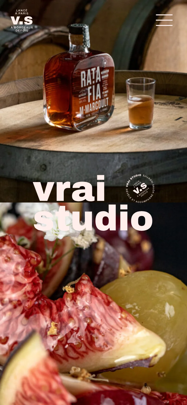 The mobile version presents a vertical stack of full-width, high-impact hero images, starting with a close-up of a liquor bottle and fruit. The 'vrai studio' logo is overlaid in large white text across the center of the images. Navigation is simplified with a hamburger menu icon in the top right and a small logo in the top left.