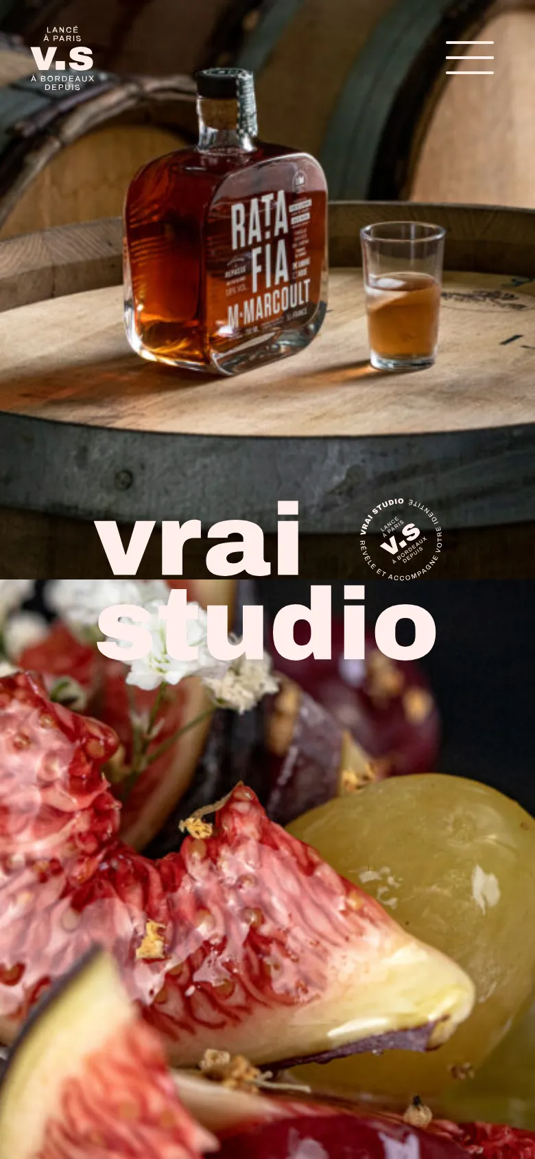The mobile version presents a vertical stack of full-width, high-impact hero images, starting with a close-up of a liquor bottle and fruit. The 'vrai studio' logo is overlaid in large white text across the center of the images. Navigation is simplified with a hamburger menu icon in the top right and a small logo in the top left.